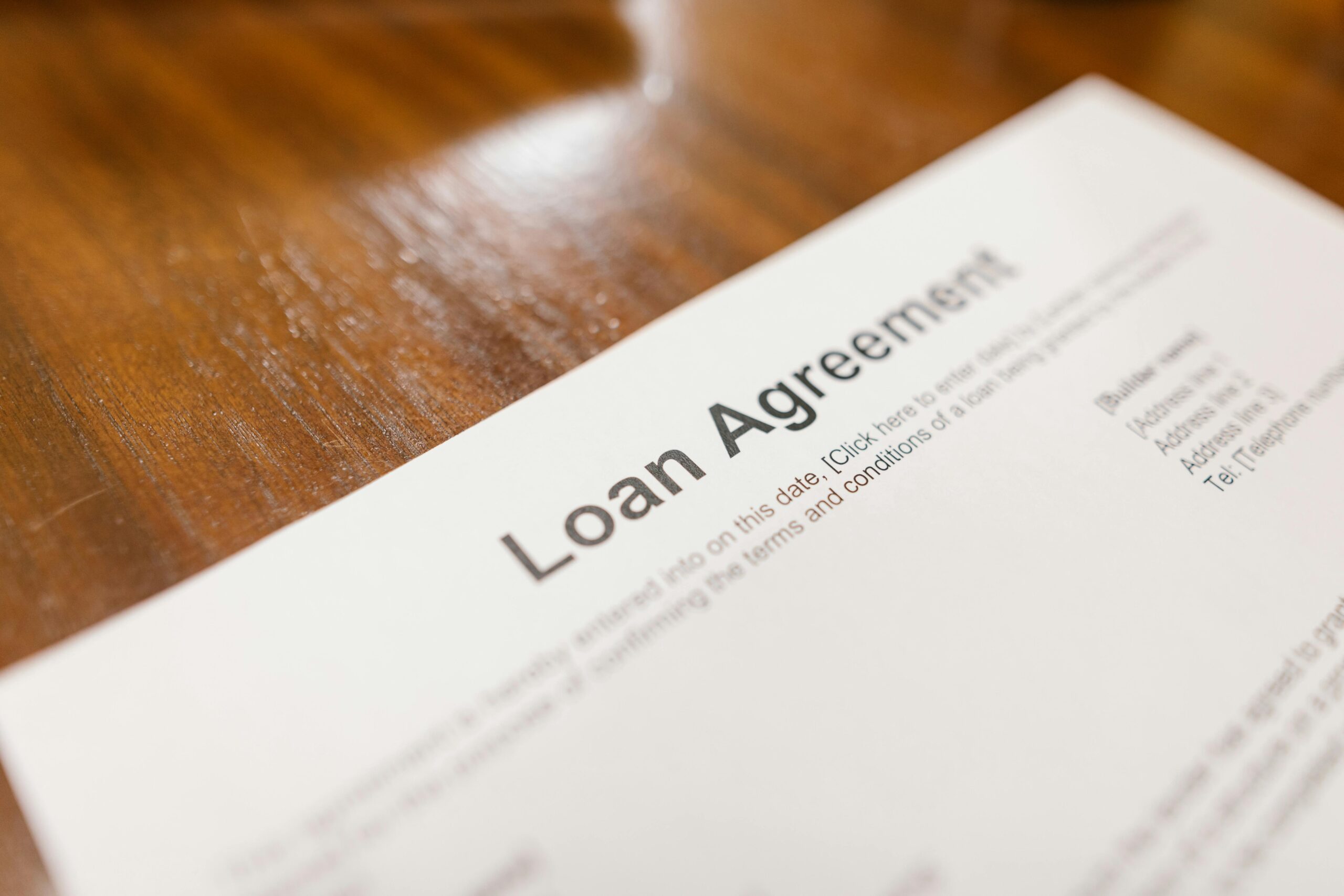 Close-up of a loan agreement document on a wooden table, representing considerations for when a payday loan might be the right solution.