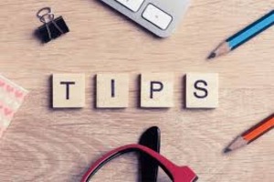 Desk with scrabble tiles spelling tips and office supplies.”