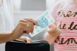 Close-up of a person handing cash to another person, representing a comparison between fast cash loans and personal loans in Singapore to choose the right borrowing option.