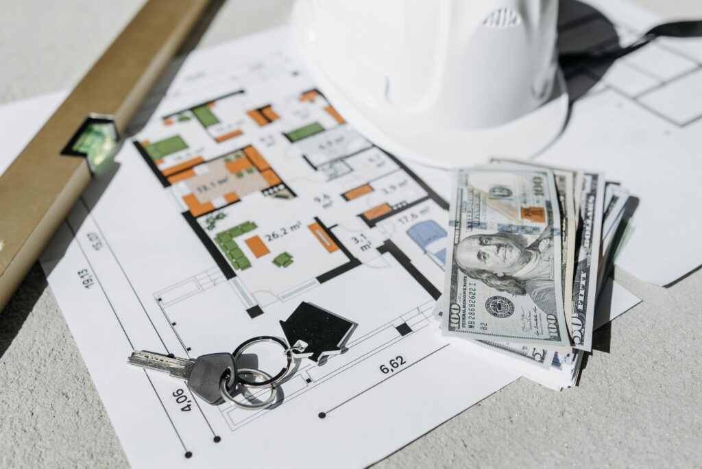 House keys, renovation floor plans, safety equipment, and cash placed together to represent renovation loans in Singapore—highlighting how foreigners can finance home improvement projects and manage renovation costs more easily.