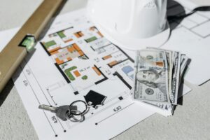 House keys, renovation floor plans, safety equipment, and cash placed together to represent renovation loans in Singapore—highlighting how foreigners can finance home improvement projects and manage renovation costs more easily.
