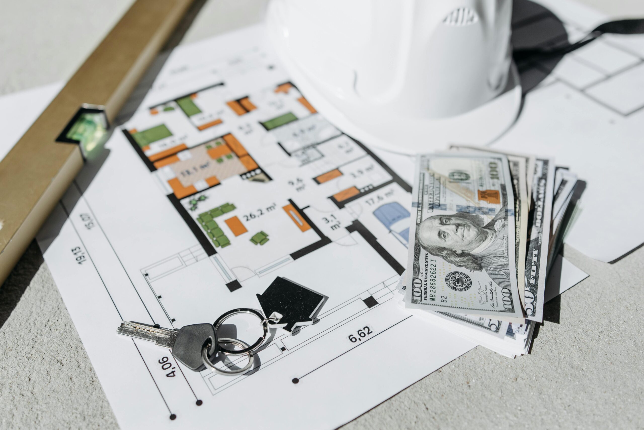 House keys, renovation floor plans, safety equipment, and cash placed together to represent renovation loans in Singapore—highlighting how foreigners can finance home improvement projects and manage renovation costs more easily.