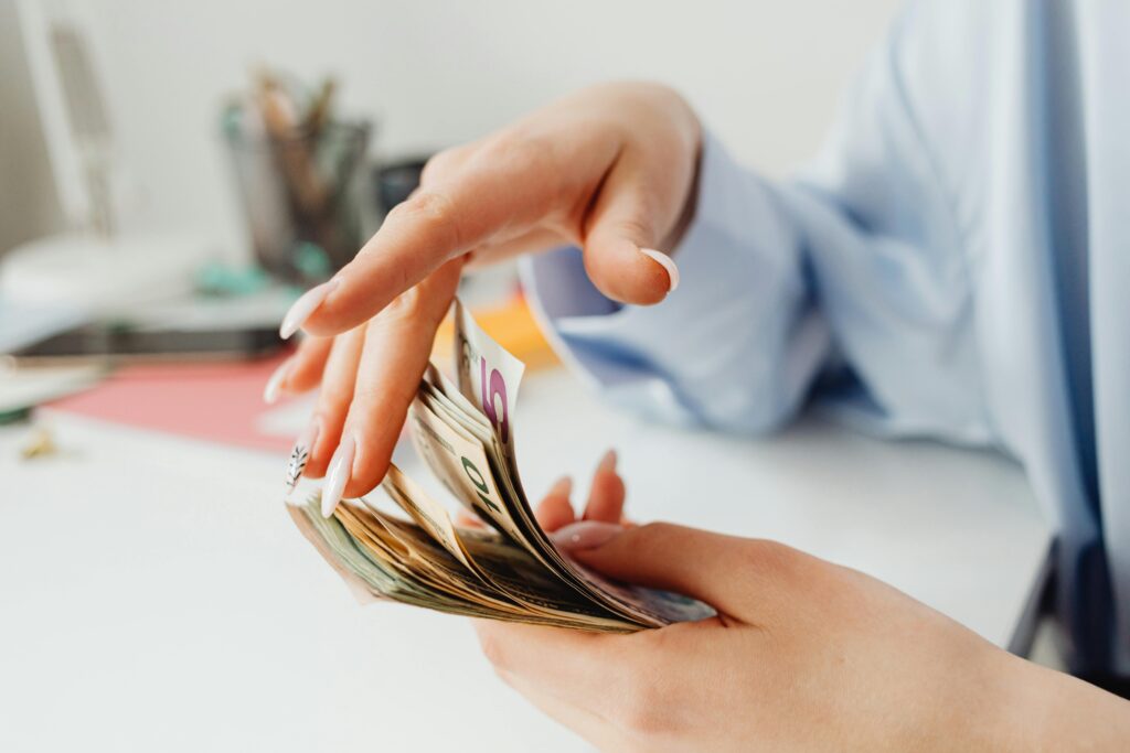 Hands counting cash carefully, representing the fast cash loan approval process, quick fund access, and responsible borrowing solutions for urgent financial needs in Singapore.